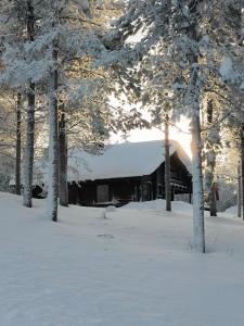 um edifício com um telhado coberto de neve na neve em Hietavilla Pläk em Ruka
