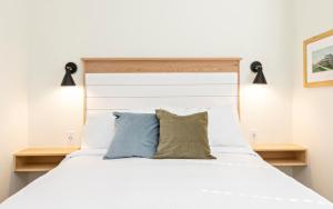 1 dormitorio con 1 cama blanca y 2 almohadas en The Waverly 100 Inn at Old Beach en Virginia Beach