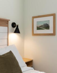 1 dormitorio con 1 cama y una foto en la pared en The Waverly 100 Inn at Old Beach en Virginia Beach