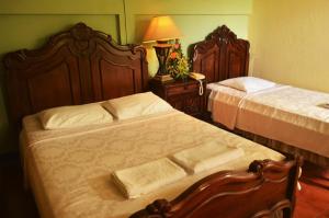 1 dormitorio con 2 camas y mesa con lámpara en Hotel Real Leon en León