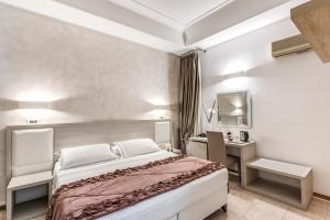 ein Hotelzimmer mit einem Bett, einem Schreibtisch und einem Bett in der Unterkunft Artemisia Palace Hotel in Palermo