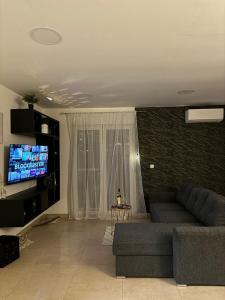 een woonkamer met een bank en een flatscreen-tv bij level UP -self check in in Osijek