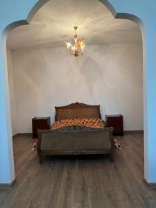 een slaapkamer met een bed in een kamer met een kroonluchter bij New Home in Gjoemri