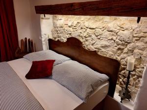 sypialnia z łóżkiem z kamienną ścianą w obiekcie Pension Sebastian w mieście Mikulov