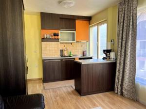 una cucina con armadi marroni e piano di lavoro di Lovely 2-bedroom rental unit in Sofia a Sofia