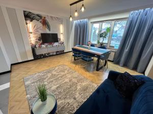 ein Wohnzimmer mit einem Tisch und einem blauen Sofa in der Unterkunft Pokoje Hotelowe "Lila" Siedlce in Siedlce