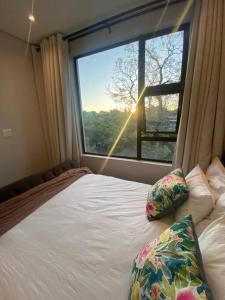 a bedroom with a bed and a large window at Load-Shedding Free Trendy 2-bed 2-bath Apartment in Johannesburg