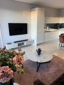 a living room with a table and a tv at Load-Shedding Free Trendy 2-bed 2-bath Apartment in Johannesburg