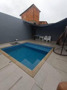 una piscina en una casa con sillas y mesa en House 91, en Montes Claros