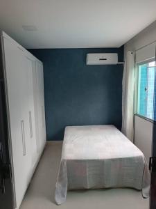 um quarto com uma cama e uma parede azul em House 91 em Montes Claros