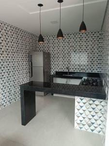 a kitchen with a black counter and a refrigerator at House 91 in Montes Claros