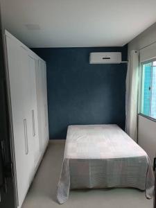 1 dormitorio con cama y pared azul en House 91, en Montes Claros