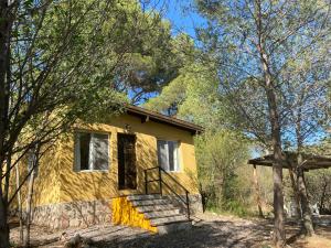 una casa amarilla con escaleras en el bosque en Cabaña Nonna Alma en San Esteban