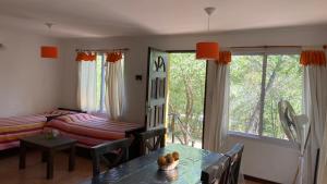 sala de estar con mesa, cama y ventana en Cabaña Nonna Alma en San Esteban