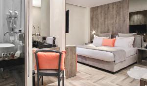 una camera d'albergo con letto e sedia di Athens The L7 Str - Luxury Boutique Collection Hotel ad Atene