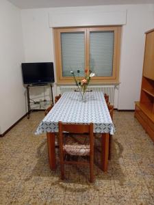 una mesa de comedor con un jarrón de flores. en Casa vacanze Monica, en Campodenno