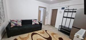 - un salon avec un canapé noir et un tapis dans l'établissement Apartament 3 cam Grand Arena, à Bucarest 1 autre photo