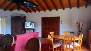 uma sala de estar com uma mesa e cadeiras e uma televisão em Casa Quinta en Maipú em Maipú