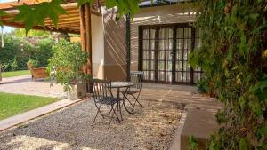eine Terrasse mit 2 Stühlen und einem Tisch vor einem Haus in der Unterkunft Casa Quinta en Maipú in Maipú