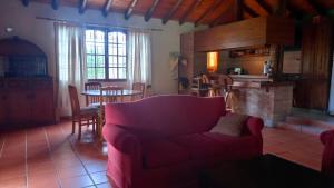 ein Wohnzimmer mit einem roten Sofa und einer Küche in der Unterkunft Casa Quinta en Maipú in Maipú