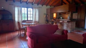 uma sala de estar com um sofá vermelho e uma cozinha em Casa Quinta en Maipú em Maipú
