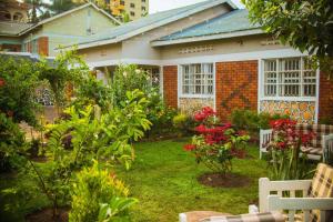 ein Haus mit einem Garten mit Blumen im Hof in der Unterkunft City Oasis Home Stays by Siima in Kampala