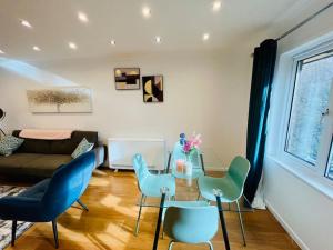 ein Wohnzimmer mit einem Tisch und blauen Stühlen in der Unterkunft Stylish Two Bedroom Flat Colindale, NW9 close to station in Colindale