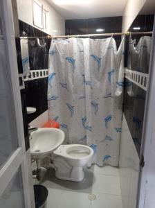 een badkamer met een toilet, een wastafel en een douchegordijn bij Casa Blanca Ciudad Jardín in Barranquilla