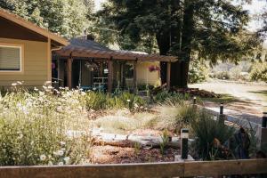 a house with a garden in front of it at Taylor Creek Lodge in Gold Beach