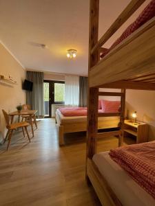 sypialnia z 2 łóżkami piętrowymi i stołem w obiekcie Talstation Heumöderntal w mieście Treuchtlingen