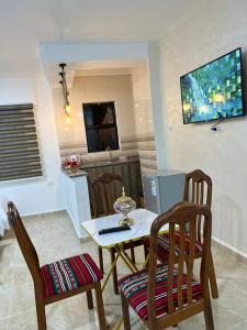 a kitchen with a table and two chairs and a tv at The guset house in Kerak