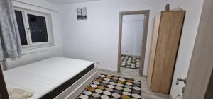 une petite chambre avec un lit et une fenêtre dans l'établissement Apartament 3 cam Grand Arena, à Bucarest
