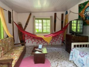 uma sala de estar com um sofá e uma rede de descanso em Recanto Riverside à beira do rio Jaguareguava na Mata Atlântica em Bertioga SP em Bertioga