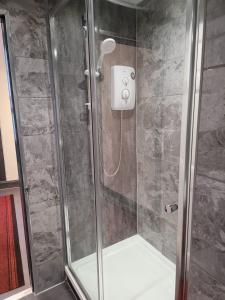 a shower with a glass door in a bathroom at Luxe rooms in Edinburgh