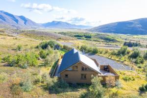 una casa en un campo con montañas en el fondo en Beautiful cabin near Grenivík, en Grenivík