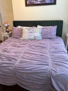 eine lila Bettdecke auf einem Bett in einem Schlafzimmer in der Unterkunft The Charleston Inn Hendersonville NC in Hendersonville