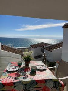 a table on a balcony with a view of the ocean at La Perla del Mar in Estepona