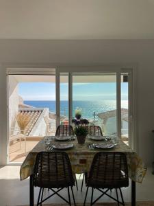 a dining room table with three chairs and a view of the ocean at La Perla del Mar in Estepona