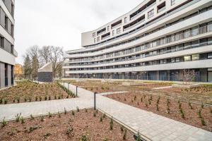 a building with a garden in front of it at Kraków Business Suite - City View with Balcony & Parking by Rentujemy in Krakow