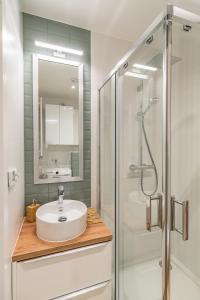 a white bathroom with a sink and a shower at Kraków Business Suite - City View with Balcony & Parking by Rentujemy in Krakow