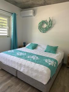 1 dormitorio con 1 cama grande con almohadas azules en Pension Irivai appartement PUATOU 1 chambre bord de mer, en Uturoa