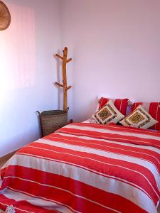 ein Schlafzimmer mit einem Bett mit einem Kreuz an der Wand in der Unterkunft kosasurfmorocco in Aourir