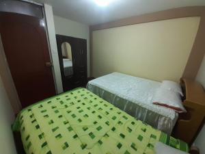 um quarto de hotel com duas camas e uma porta em Inca Wasi em Puno