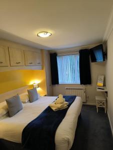 a hotel room with two beds with towels on them at Ghyll Rigg in Bowness-on-Windermere