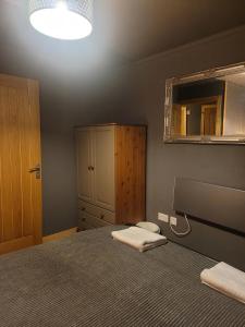 een slaapkamer met een bed met een spiegel en een wastafel bij THE MOORINGS in Broadford