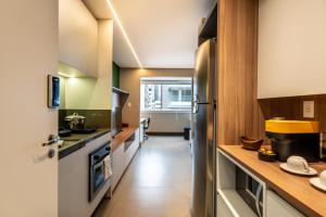 a kitchen with a stainless steel refrigerator and wooden counters at Pinheiros Faria Lima, Novo, 38M2, WIFI700MB - Traveller Awards 2024 in São Paulo