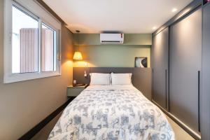 a small bedroom with a bed and a window at Pinheiros Faria Lima, Novo, 38M2, WIFI700MB - Traveller Awards 2024 in Sao Paulo