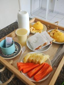un vassoio con piatti di cibo su un tavolo di Pousada Claiô Suíte Estivas a Garanhuns