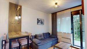 a living room with a couch and a table at Apartman Istra_28 Titova Vila in Zlatibor