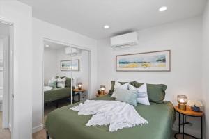 園林市的住宿－Cozy 1bd 1ba, Sleeps 3, Close to Disney & Beaches，一间卧室配有绿色的床和镜子